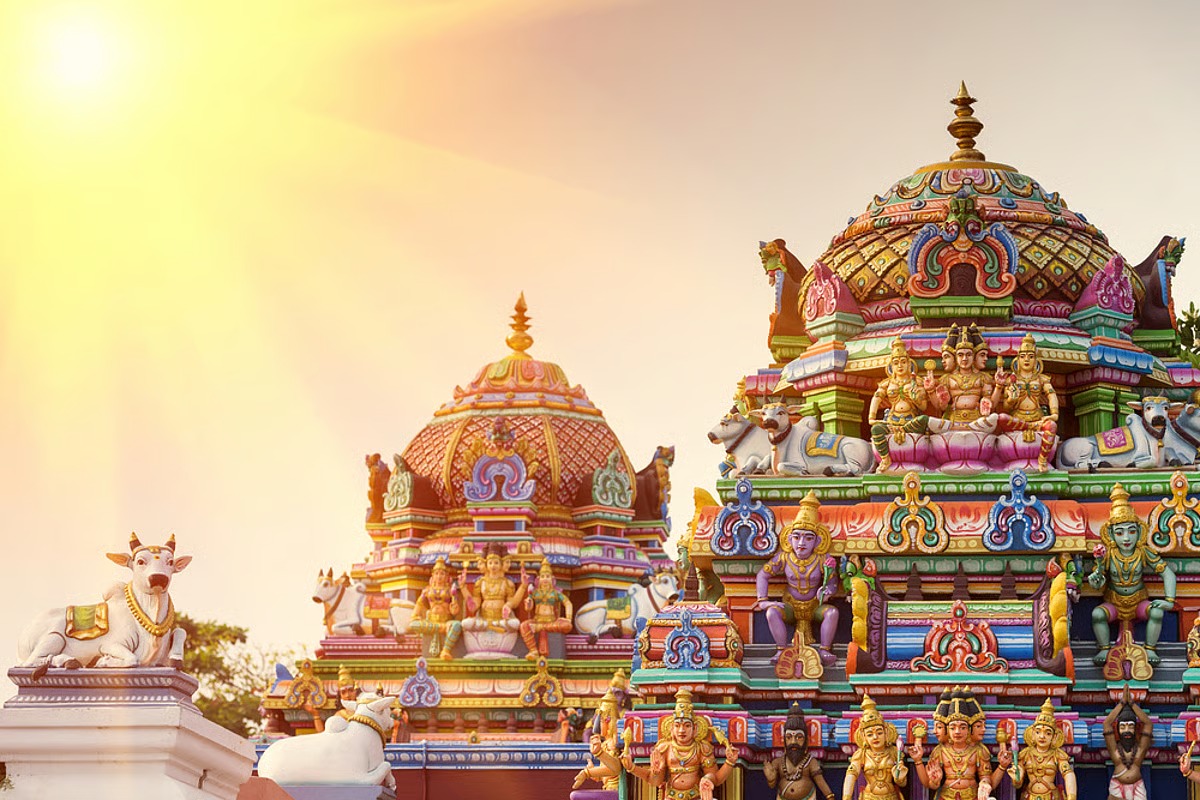 The painted towers of a South Indian temple, Nandi figures on the walls, in evening sun